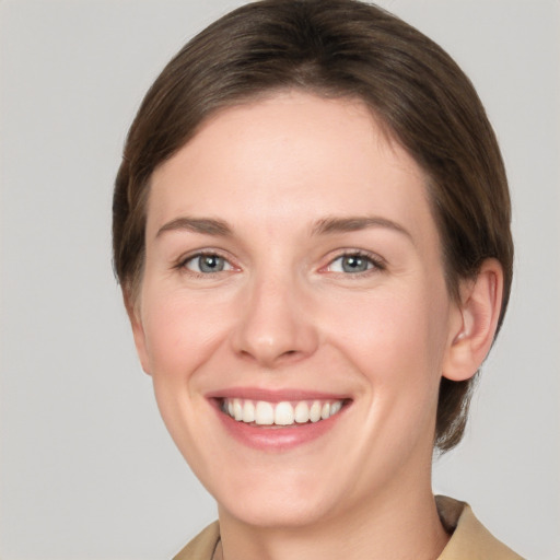 Joyful white young-adult female with short  brown hair and grey eyes