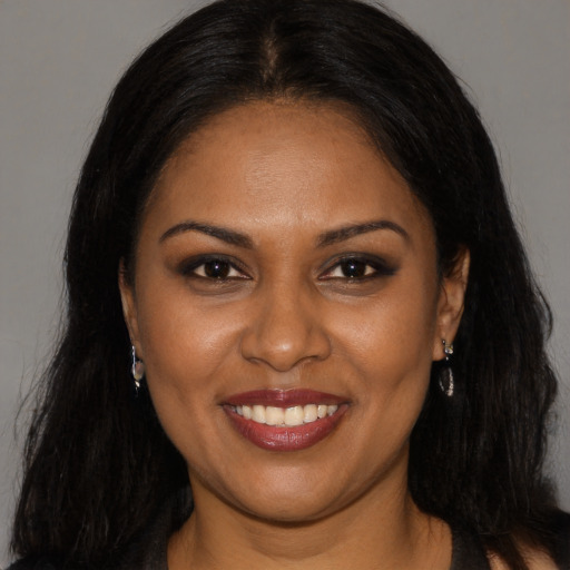Joyful black young-adult female with long  brown hair and brown eyes