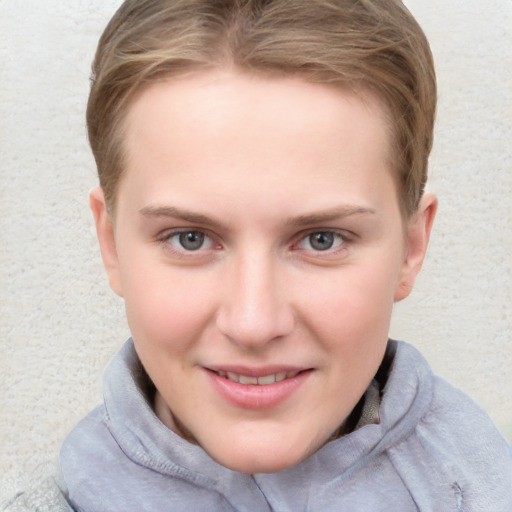 Joyful white young-adult female with short  brown hair and blue eyes