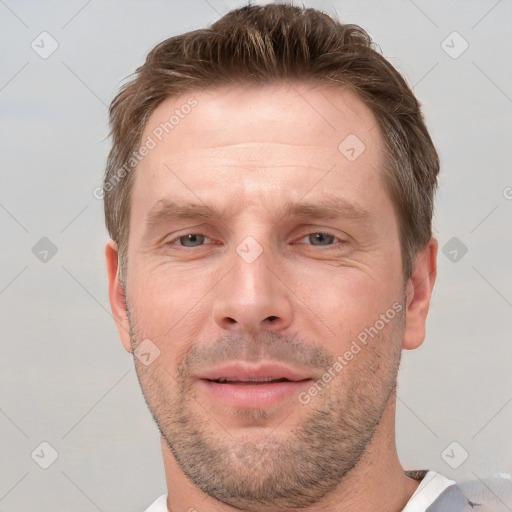 Joyful white adult male with short  brown hair and grey eyes