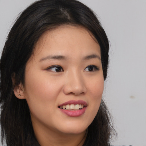 Joyful asian young-adult female with long  brown hair and brown eyes