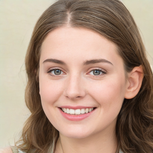 Joyful white young-adult female with long  brown hair and blue eyes