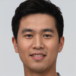 Joyful asian young-adult male with short  black hair and brown eyes