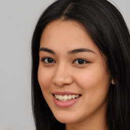 Joyful latino young-adult female with long  brown hair and brown eyes