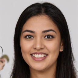 Joyful latino young-adult female with long  brown hair and brown eyes