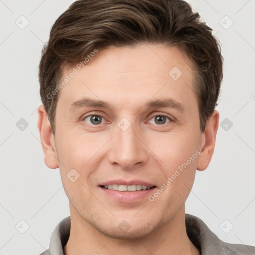 Joyful white young-adult male with short  brown hair and grey eyes