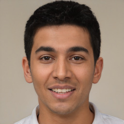 Joyful latino young-adult male with short  black hair and brown eyes