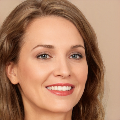 Joyful white young-adult female with long  brown hair and green eyes