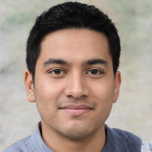 Joyful latino young-adult male with short  black hair and brown eyes