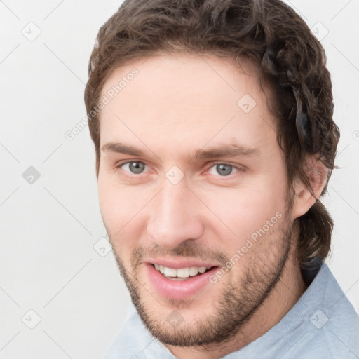 Joyful white young-adult male with short  brown hair and grey eyes