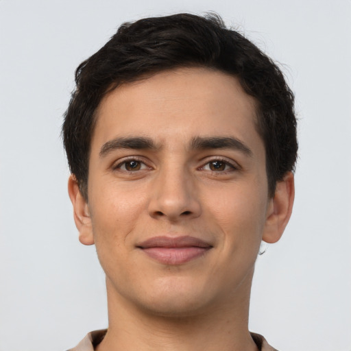 Joyful latino young-adult male with short  brown hair and brown eyes