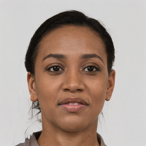 Joyful black young-adult female with short  brown hair and brown eyes