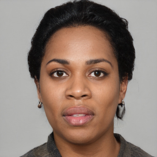 Joyful black young-adult female with short  black hair and brown eyes