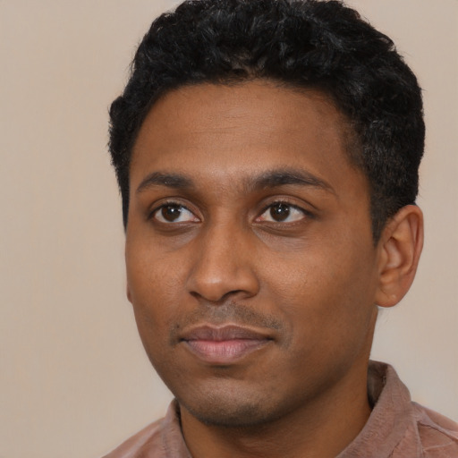 Joyful black young-adult male with short  black hair and brown eyes