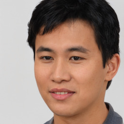 Joyful asian young-adult male with short  black hair and brown eyes