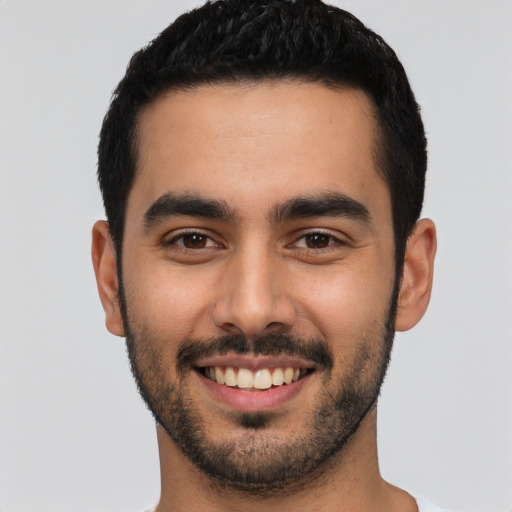 Joyful latino young-adult male with short  black hair and brown eyes