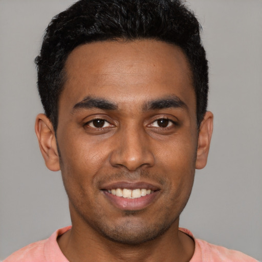 Joyful black young-adult male with short  black hair and brown eyes
