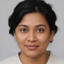 Joyful latino young-adult female with medium  brown hair and brown eyes