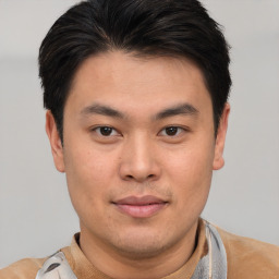 Joyful asian young-adult male with short  brown hair and brown eyes