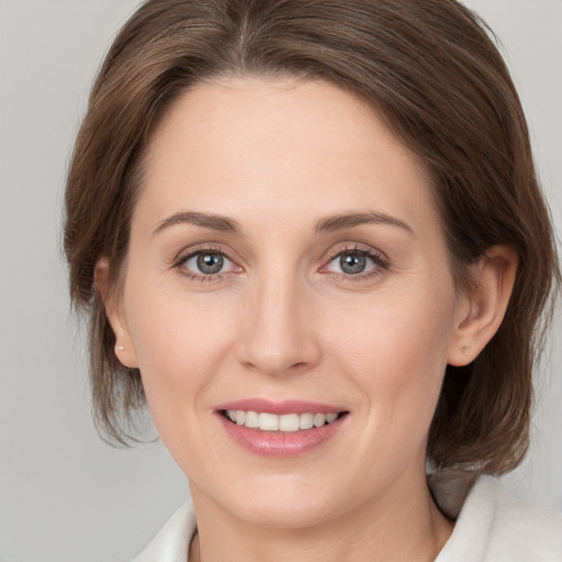 Joyful white young-adult female with medium  brown hair and grey eyes