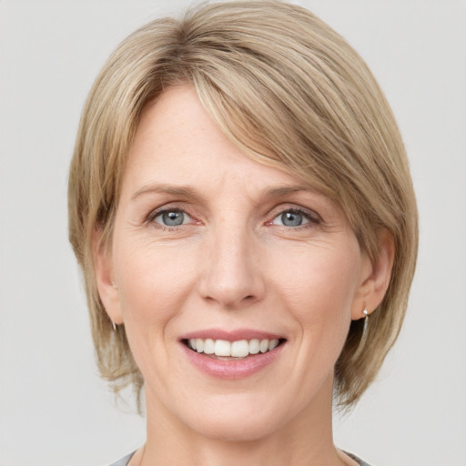 Joyful white adult female with medium  brown hair and grey eyes