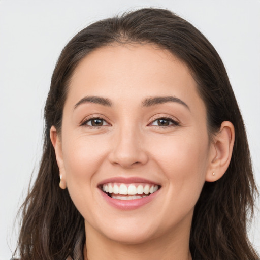 Joyful white young-adult female with long  brown hair and brown eyes