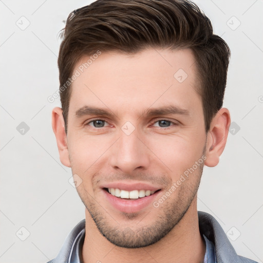 Joyful white young-adult male with short  brown hair and grey eyes