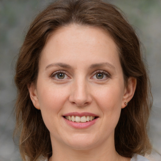 Joyful white young-adult female with medium  brown hair and green eyes