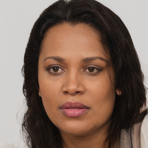Joyful black young-adult female with long  brown hair and brown eyes