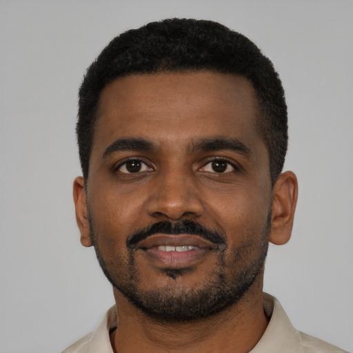 Joyful black young-adult male with short  black hair and brown eyes