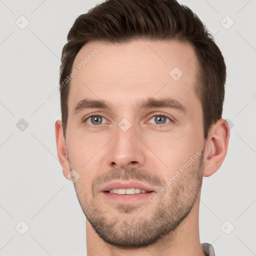 Joyful white young-adult male with short  brown hair and grey eyes