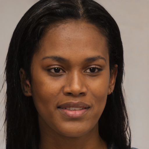 Joyful black young-adult female with long  black hair and brown eyes