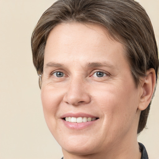 Joyful white adult female with medium  brown hair and grey eyes