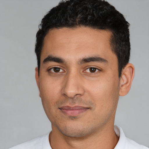 Joyful white young-adult male with short  black hair and brown eyes