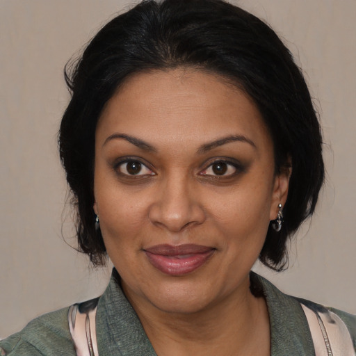 Joyful black adult female with medium  brown hair and brown eyes