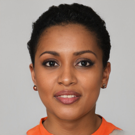 Joyful black young-adult female with short  black hair and brown eyes