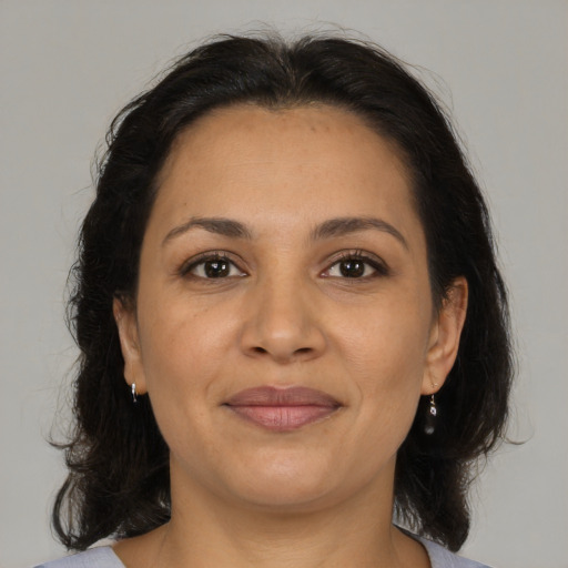 Joyful latino adult female with medium  brown hair and brown eyes