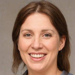 Joyful white adult female with medium  brown hair and grey eyes