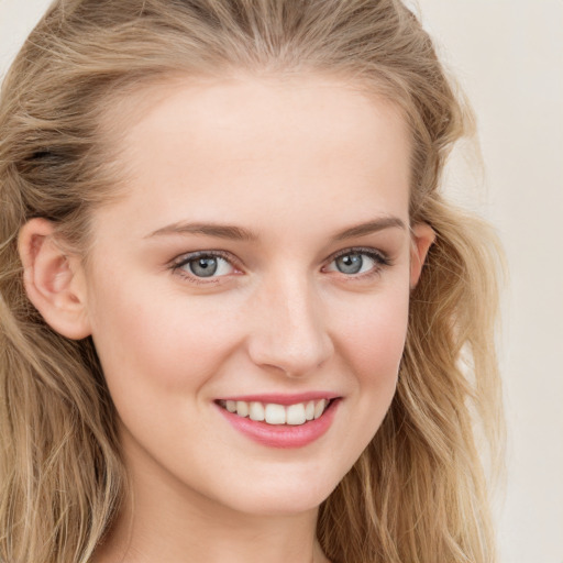 Joyful white young-adult female with long  brown hair and blue eyes