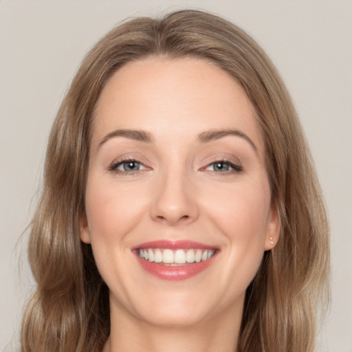 Joyful white young-adult female with medium  brown hair and grey eyes