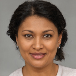 Joyful black adult female with medium  brown hair and brown eyes