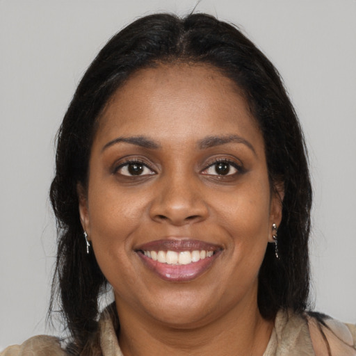 Joyful black young-adult female with long  brown hair and brown eyes