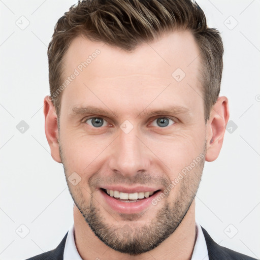 Joyful white young-adult male with short  brown hair and grey eyes