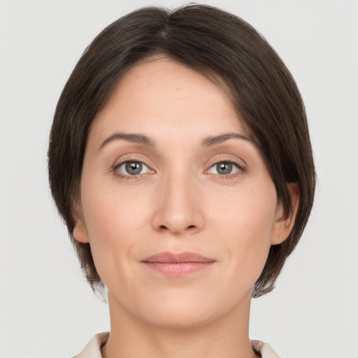 Joyful white young-adult female with medium  brown hair and grey eyes