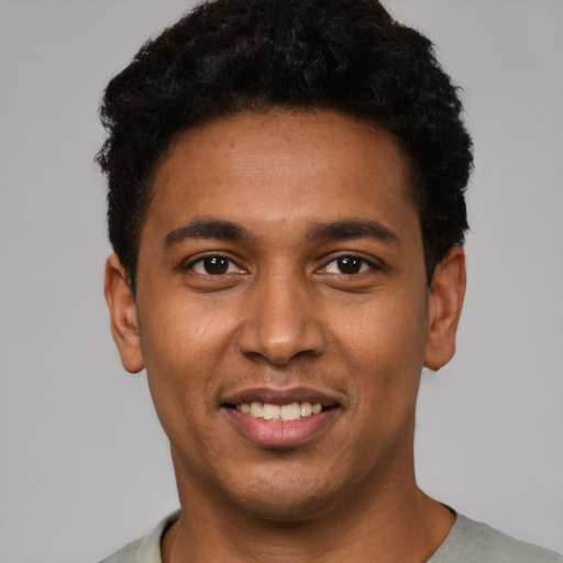 Joyful black young-adult male with short  black hair and brown eyes