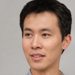 Joyful asian young-adult male with short  black hair and brown eyes