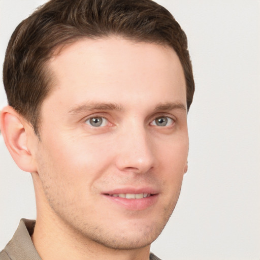 Joyful white young-adult male with short  brown hair and grey eyes