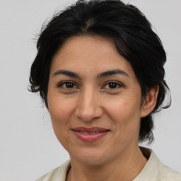 Joyful latino adult female with medium  brown hair and brown eyes