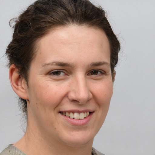 Joyful white young-adult female with medium  brown hair and grey eyes