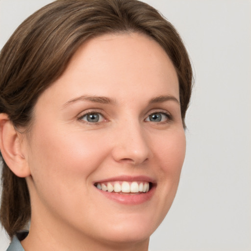 Joyful white young-adult female with medium  brown hair and green eyes